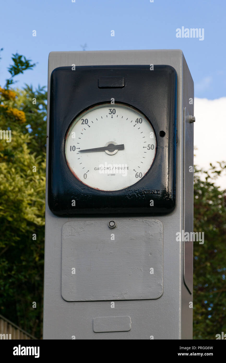 The front dial face of a large meter showing gallons per minute indicators Stock Photo