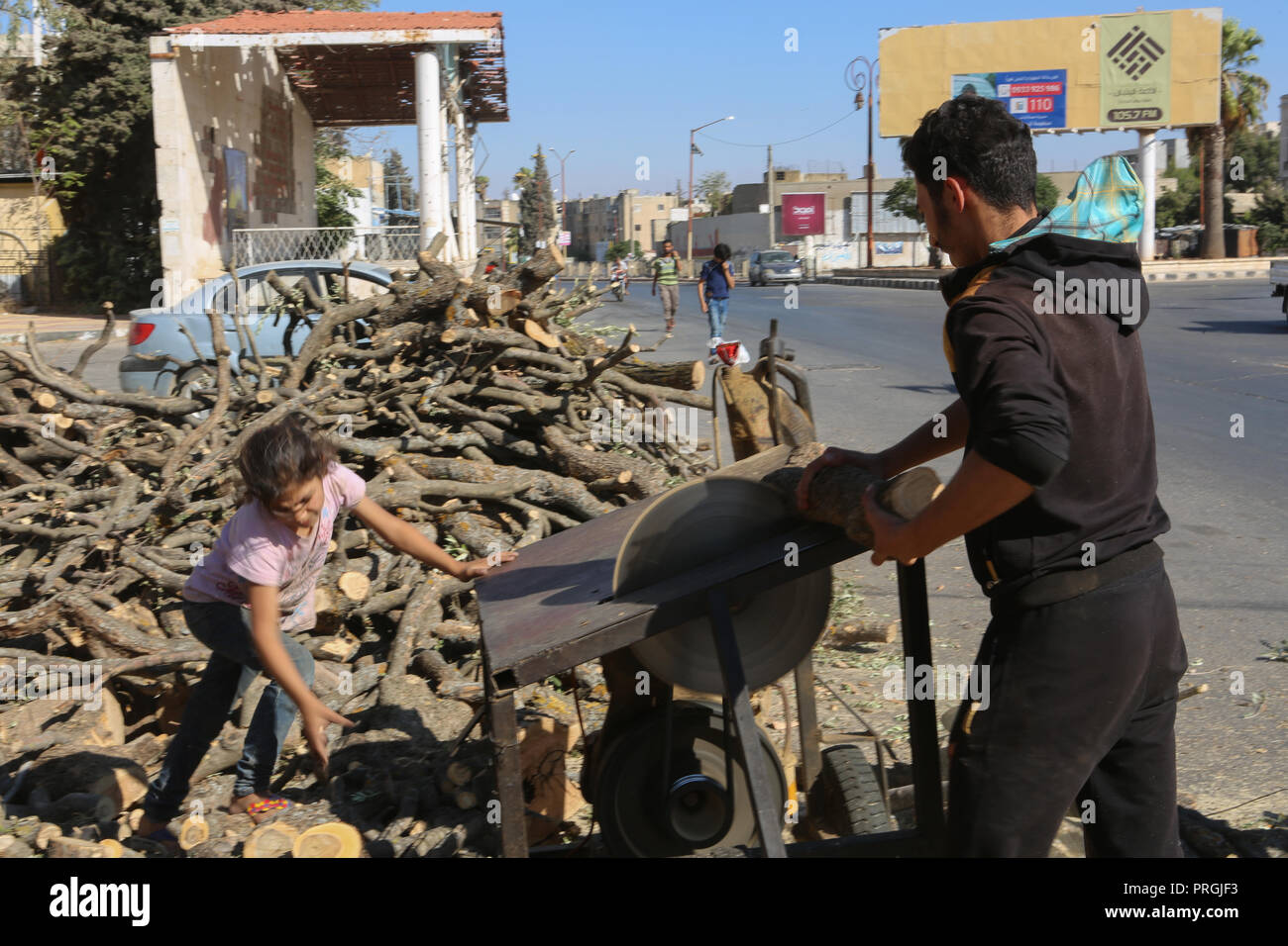 September 14, 2018 - Syrians in the city of Idlib chop forest wood with a chainsaw to prepare firewood for heating. Many Syrians resort to logs for heating as with the conflict the price of diesel has risen from approximately $28 to approximately $100 per barrel, accompanied by a ten-fold devaluation of the Syrian currency. Before the onset of the conflict kerosene was mainly used in heating during the winter season in Idlib, but since the conflict started many Syrians have resorted to cutting down trees from nearby forests and woodlands to stay warm while facing fuel rocketing prices and fue Stock Photo