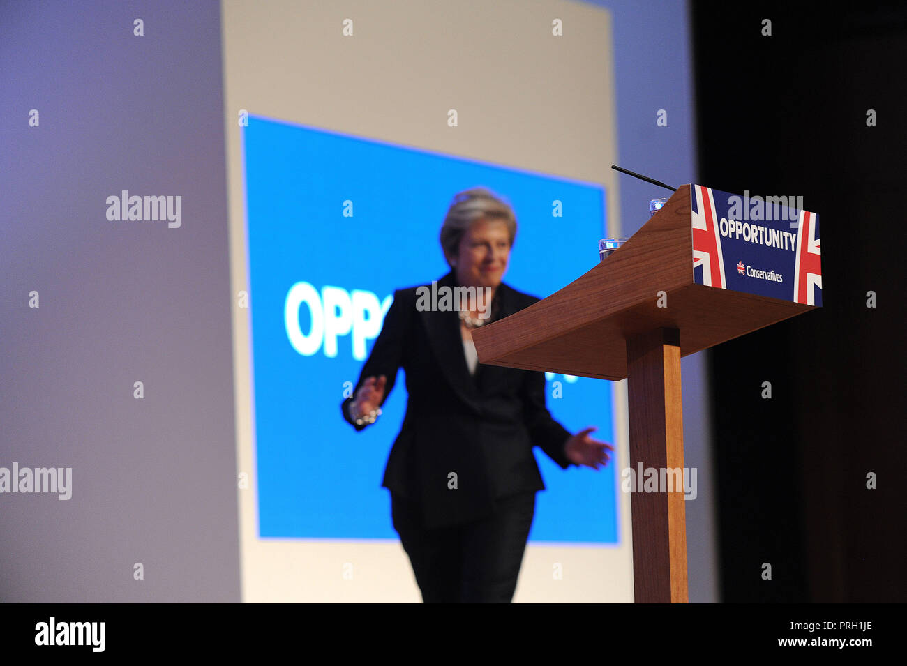 Birmingham, England. 3rd October, 2018.  Theresa May MP, Prime Minister and Leader of the Conservative Party, dances onto stage to deliver her keynote speech to conference on the closing session of the fourth day of the Conservative Party annual conference at the ICC.  Kevin Hayes/Alamy Live News Credit: Kevin Hayes/Alamy Live News Stock Photo