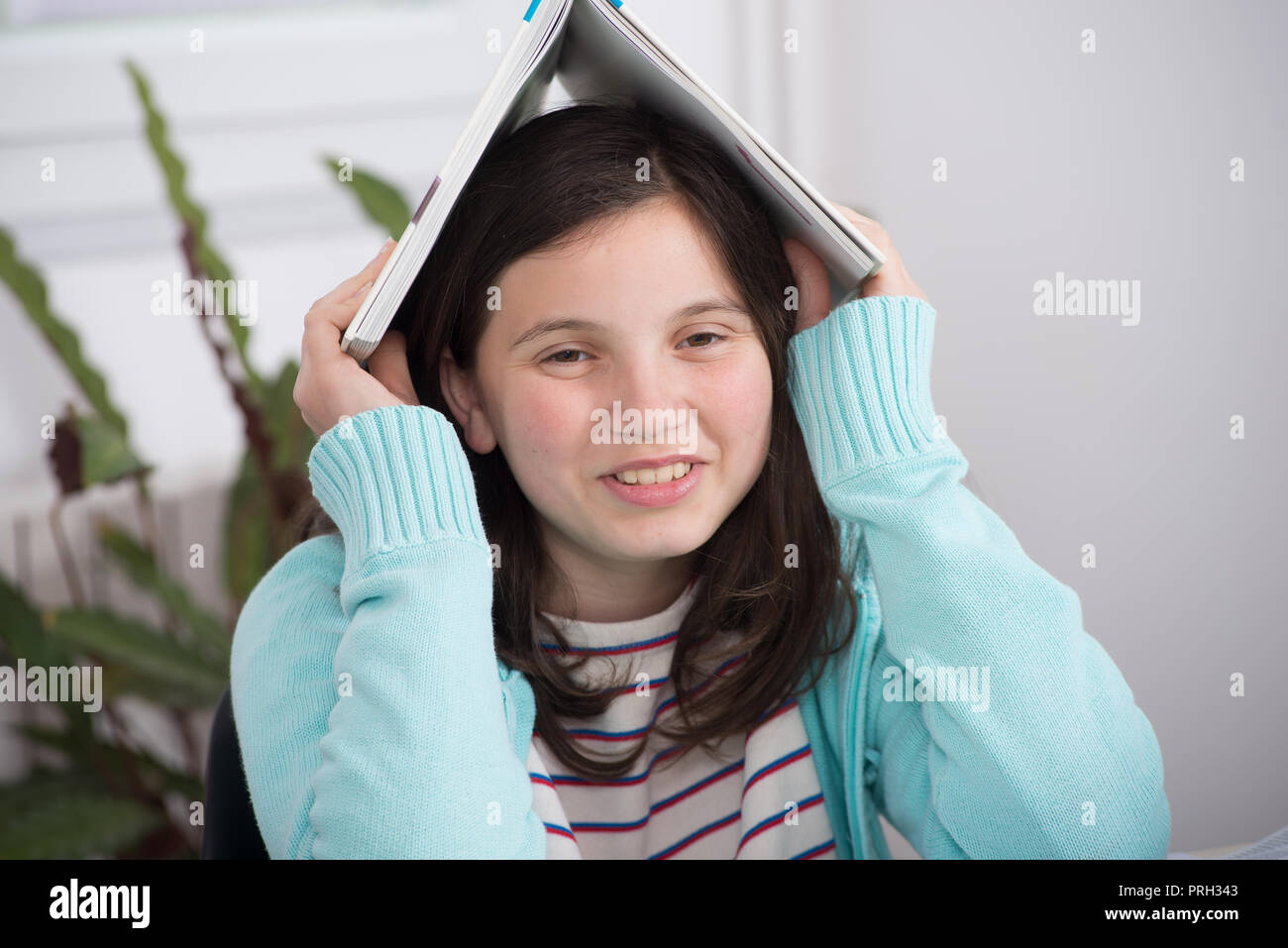 funny teenage girl with a book on her head Stock Photo - Alamy