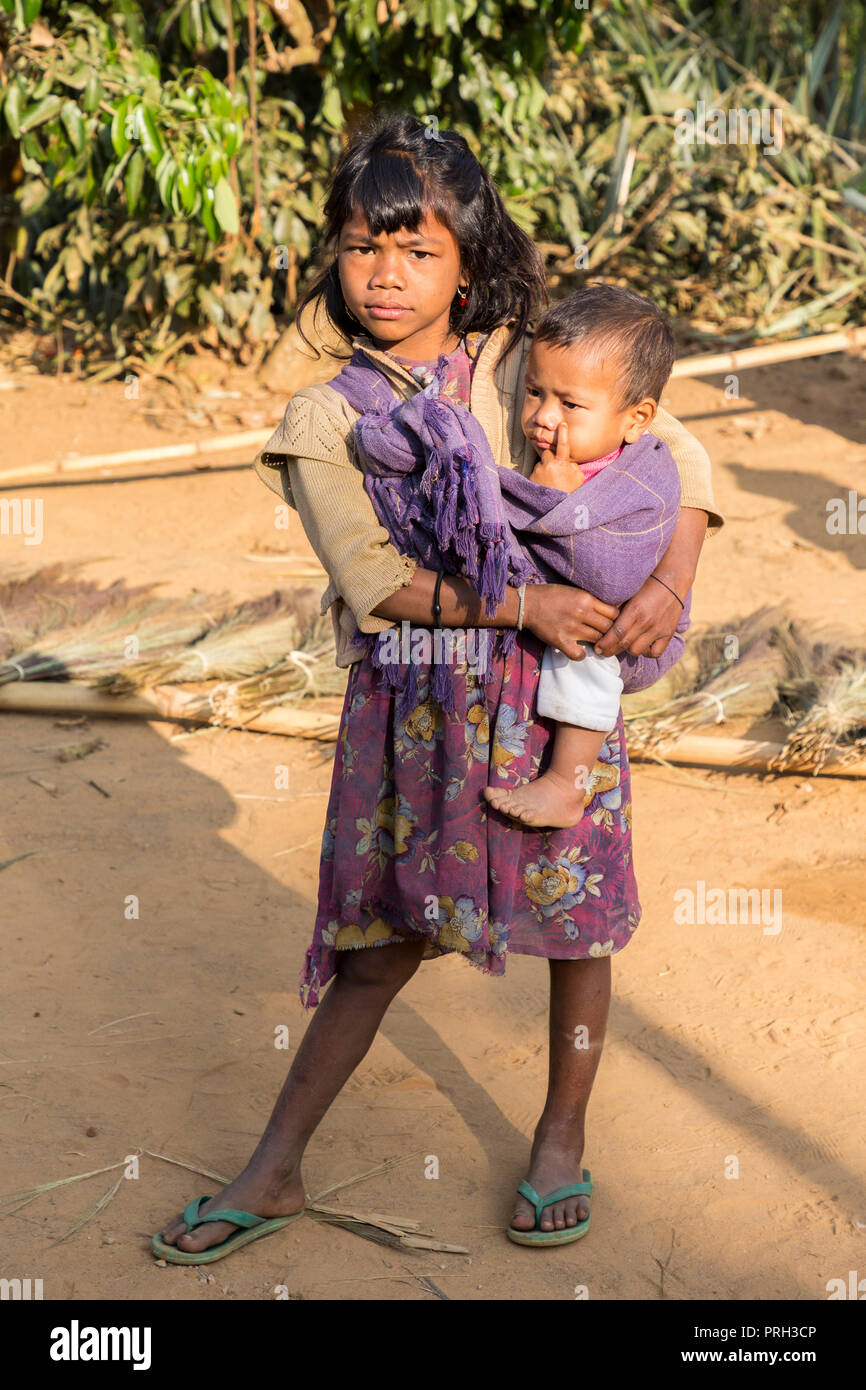 Girl carrying young child on hip, Meghalaya, India Stock Photo