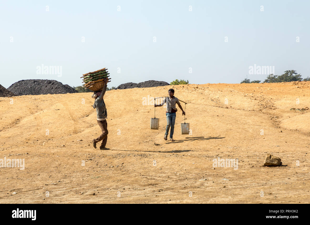 Boys carrying baskets and water for coal mine workers, Meghalaya, India Stock Photo