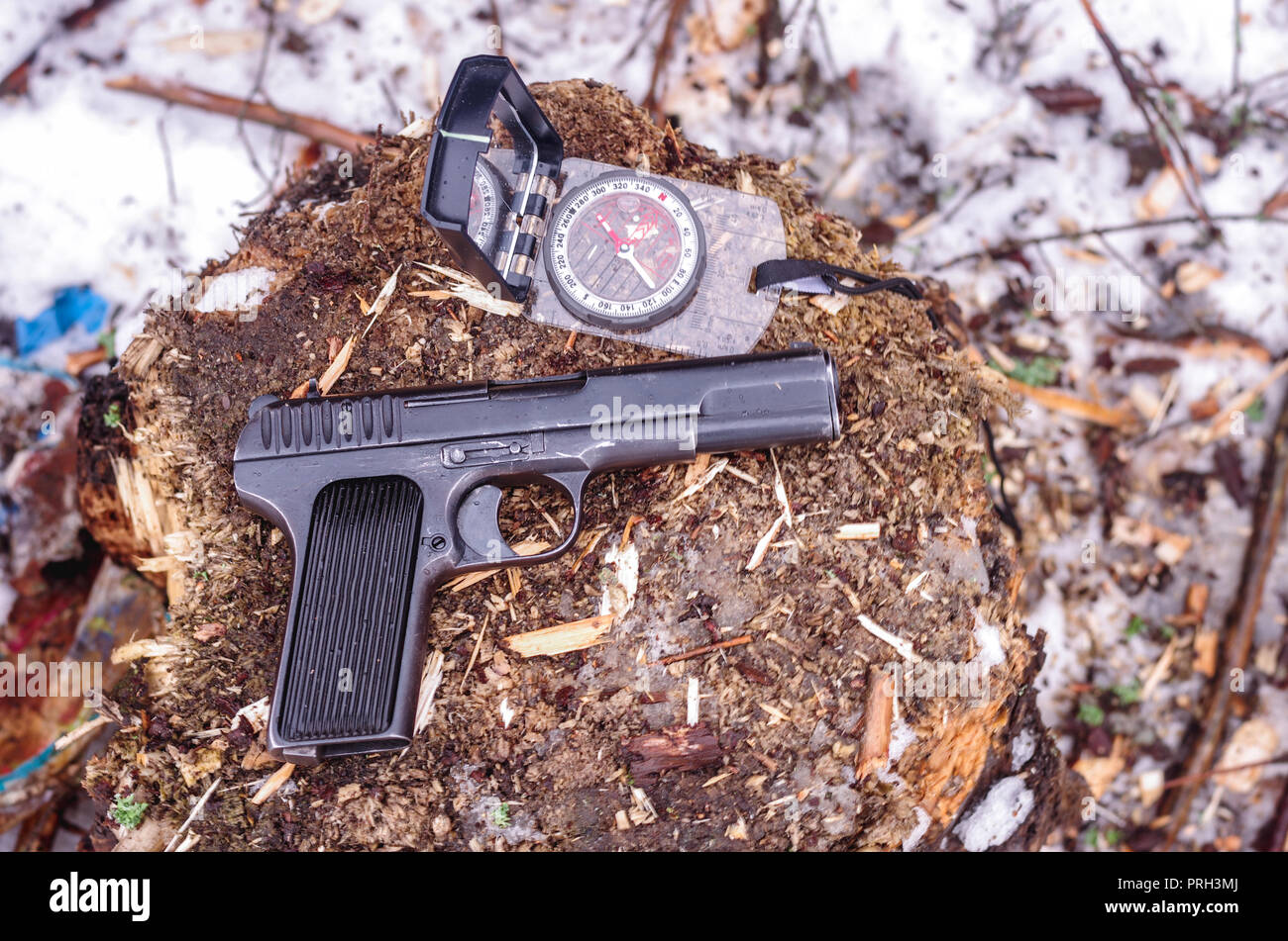 Black pistol and compass. The Makarov pistol. The gun is made in the USSR. Top. Stock Photo