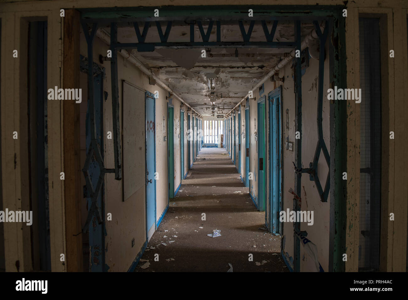 Corridor of prison cell doors inside an abandoned prison. Stock Photo