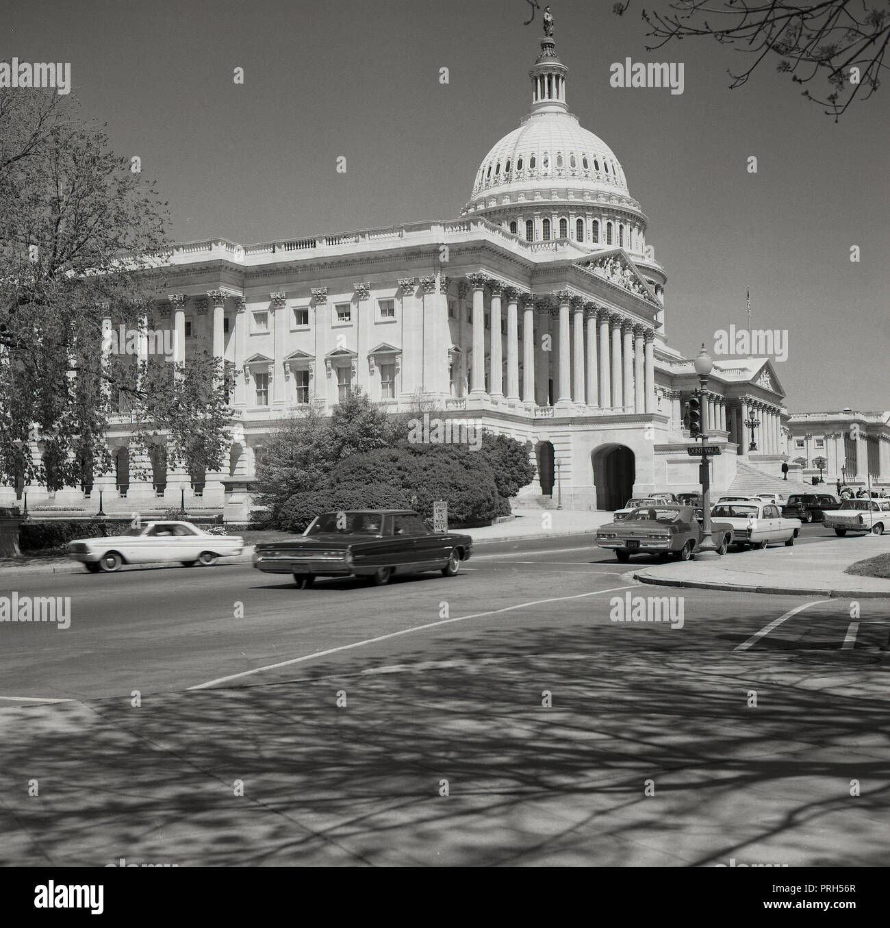 1950s, historical, summertime and across a road with American cars of the era, a view of the iconic, domed building of the United States Capitol, where the US congress meets. The House of Representatives and the Senate meet there and it is the centre of the legislative branch of the US federal government, Stock Photo