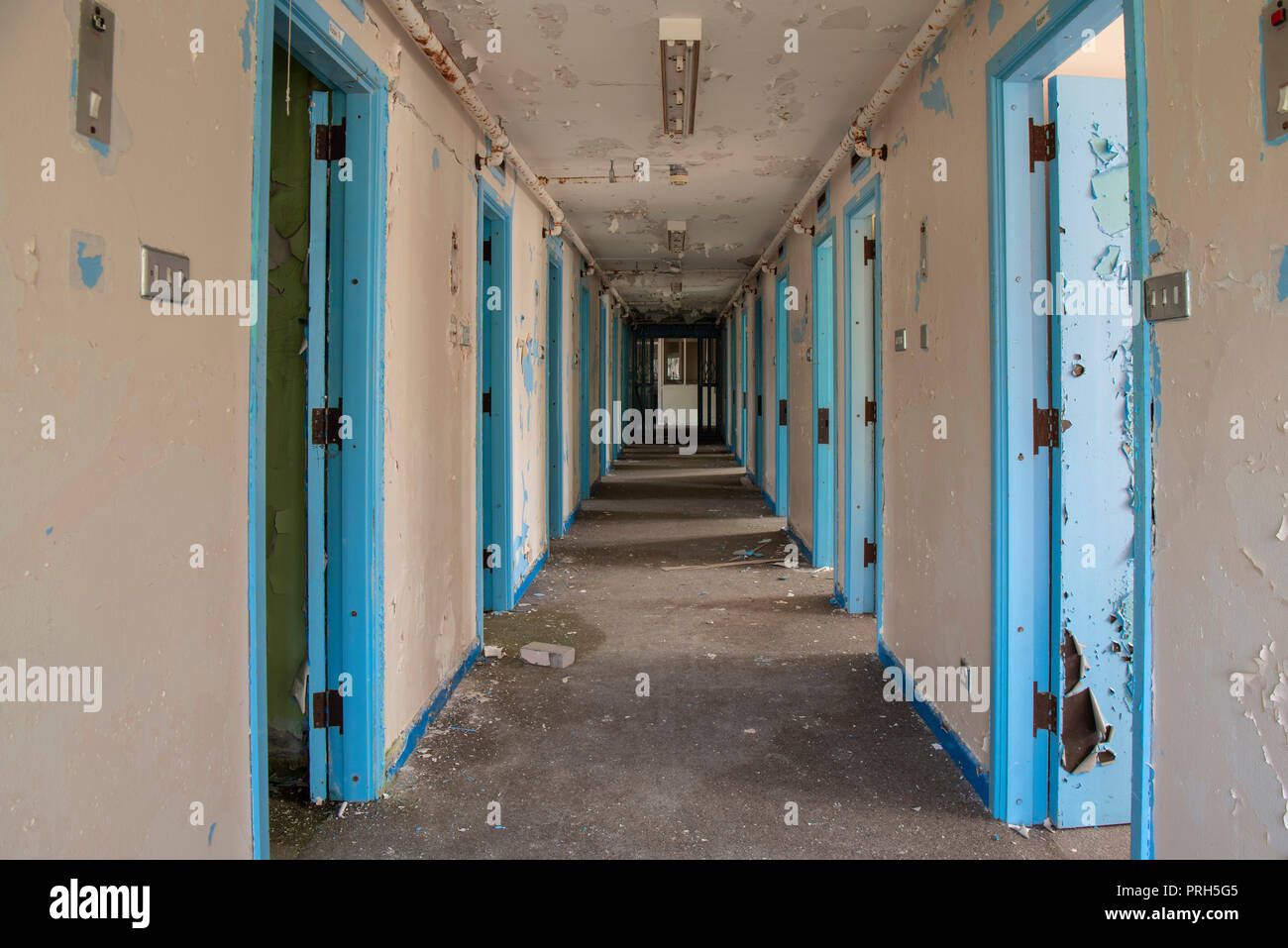 Corridor of prison cell doors inside an abandoned prison. Stock Photo