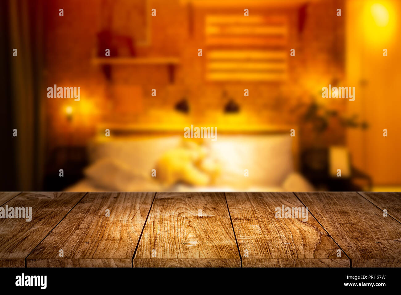 Wood foreground with blur night bedroom for montage display products background. Stock Photo