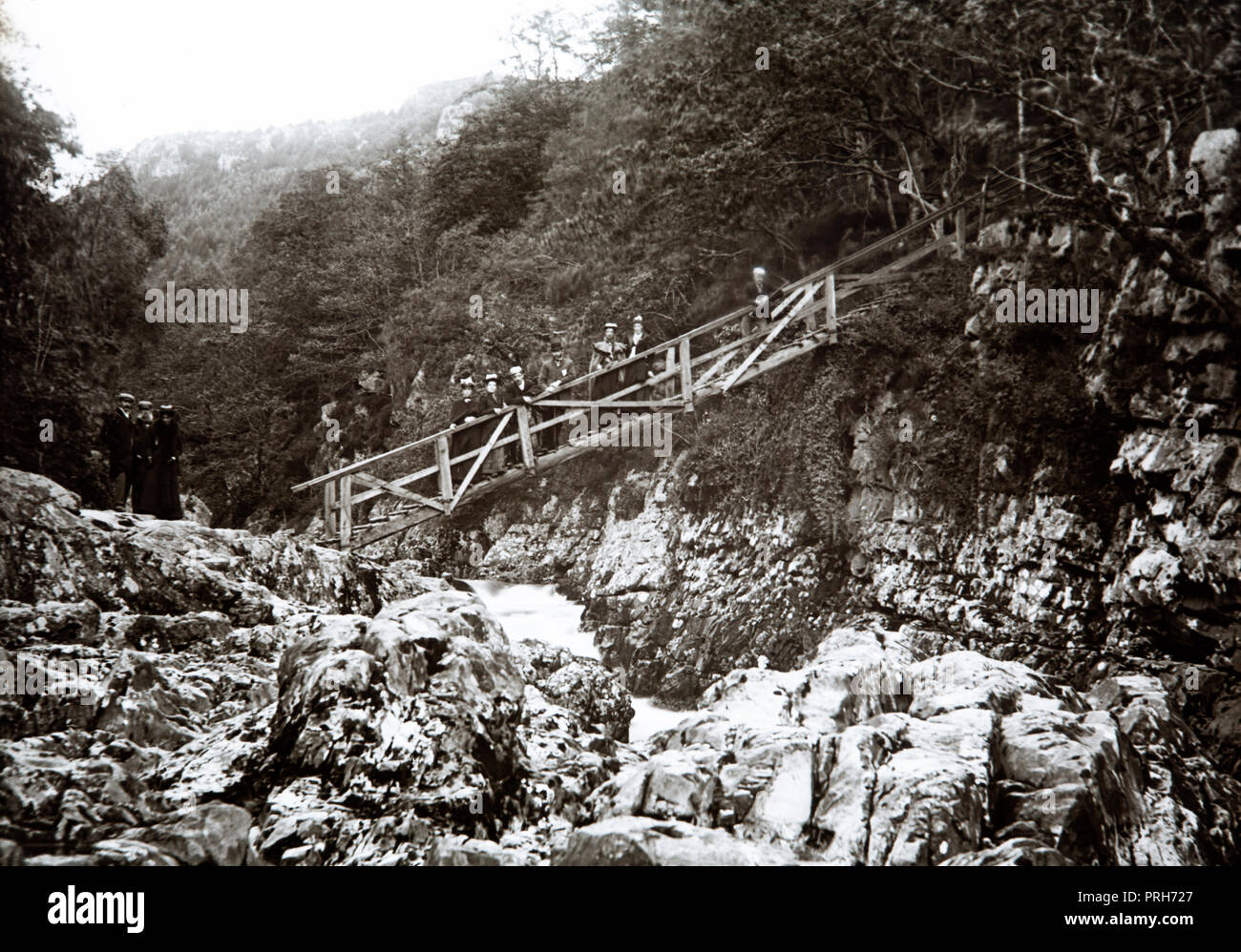 Early twentieth century photograph showing the original Miners Bridge crossing the River LLugwy in Betws Y Coed in the Snowdonia National park in North Wales. Stock Photo