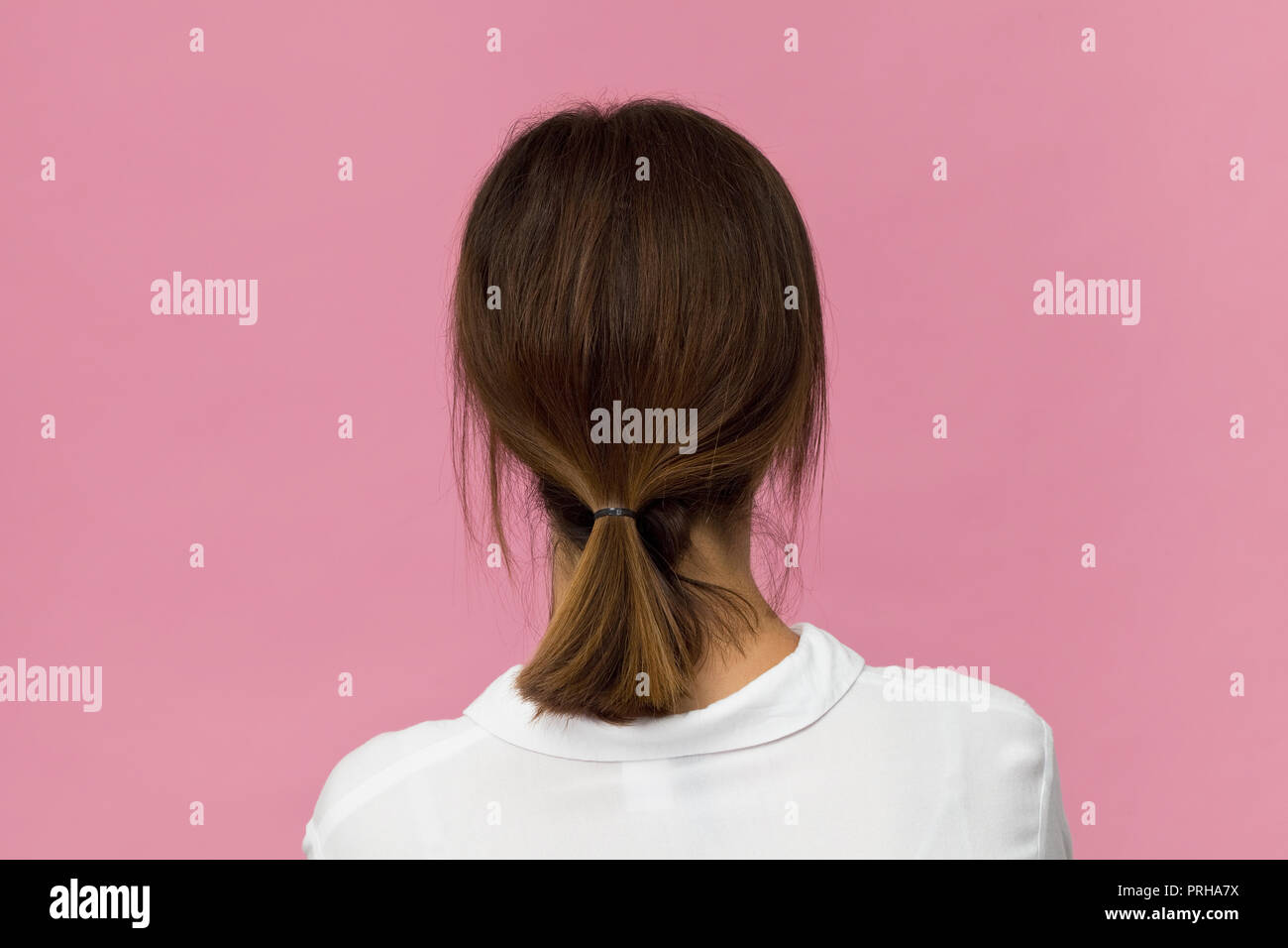 Back view of young woman with brown hair. She is waiting of someone Stock Photo