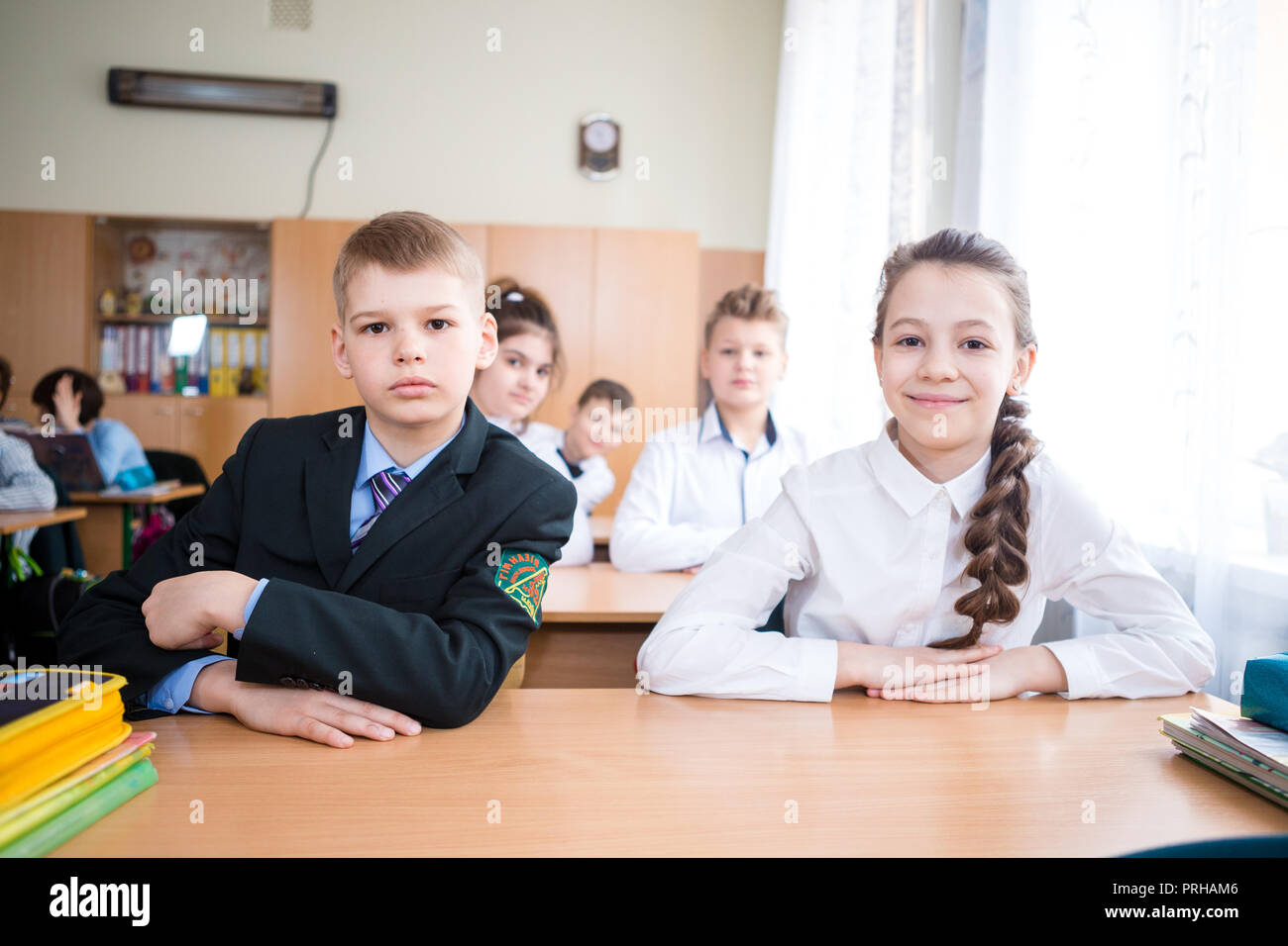 Ukraine. Kiev. May 5, 2018. Junior school, college. pair two children Caucasian nationality, pupils school, sit desk school class room. On table books Stock Photo