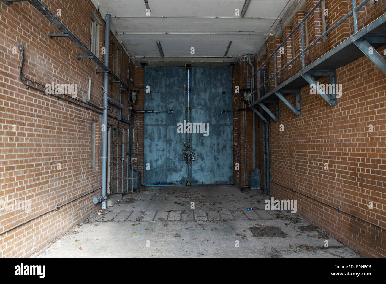 Hydraulically operated steel gates inside the vehicle bay of a prison. Stock Photo