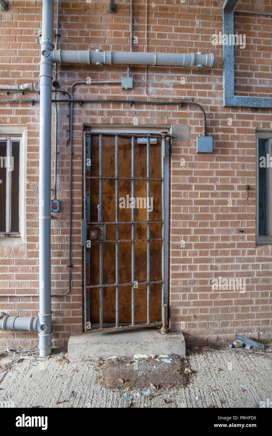 Steel bars gate protects a door of a prison. Stock Photo