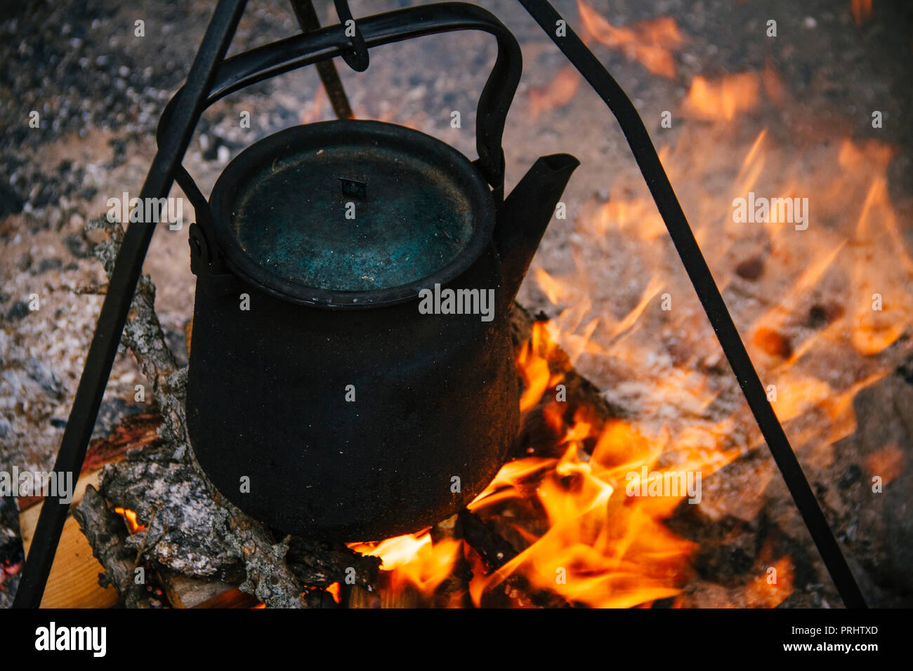 Old kettle is burning at the stake, tourists boil water on the fire