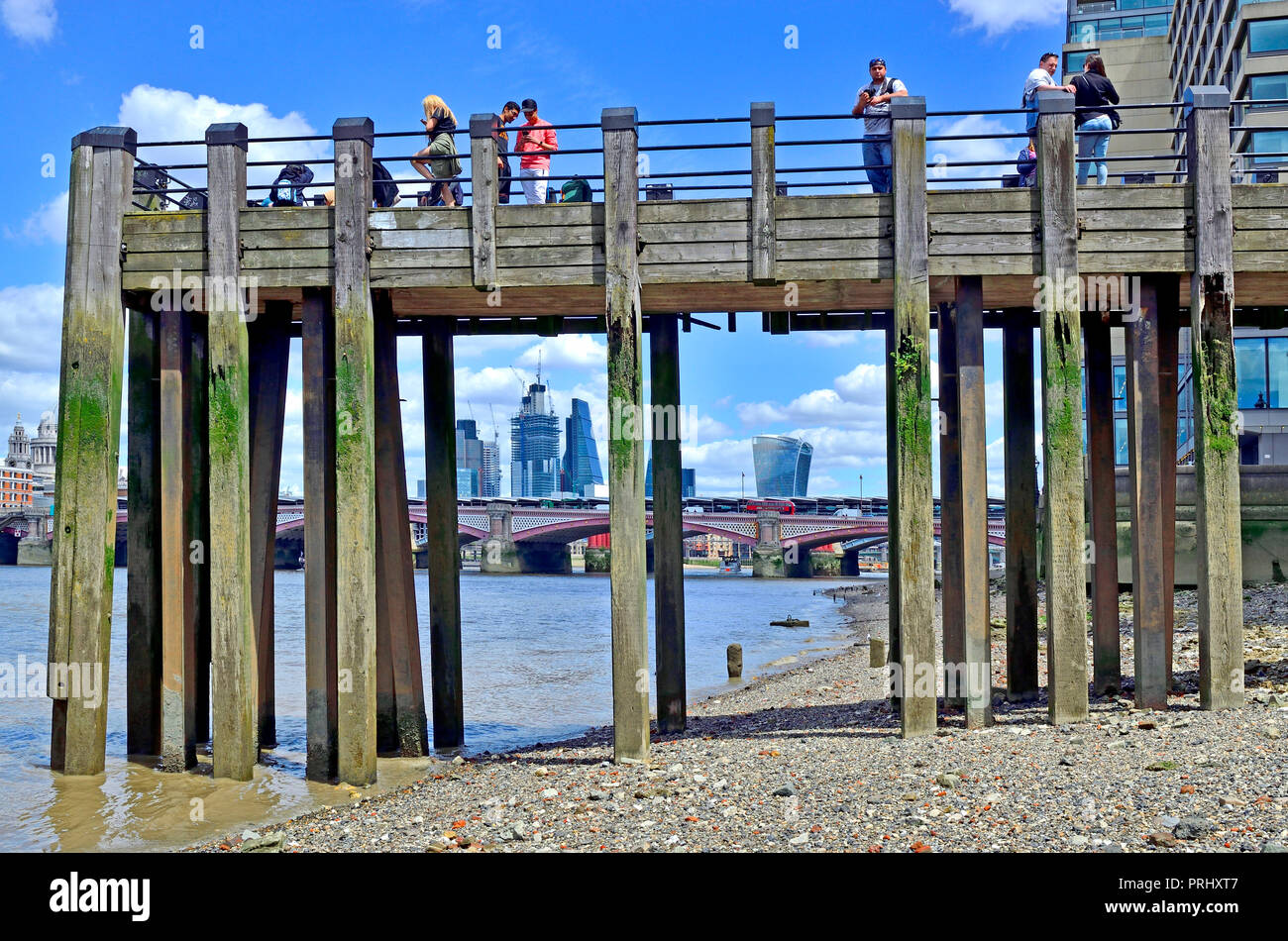 People on a wooden pier on Gabriel's Beach, River Thames at low tide. London, England, UK. Stock Photo