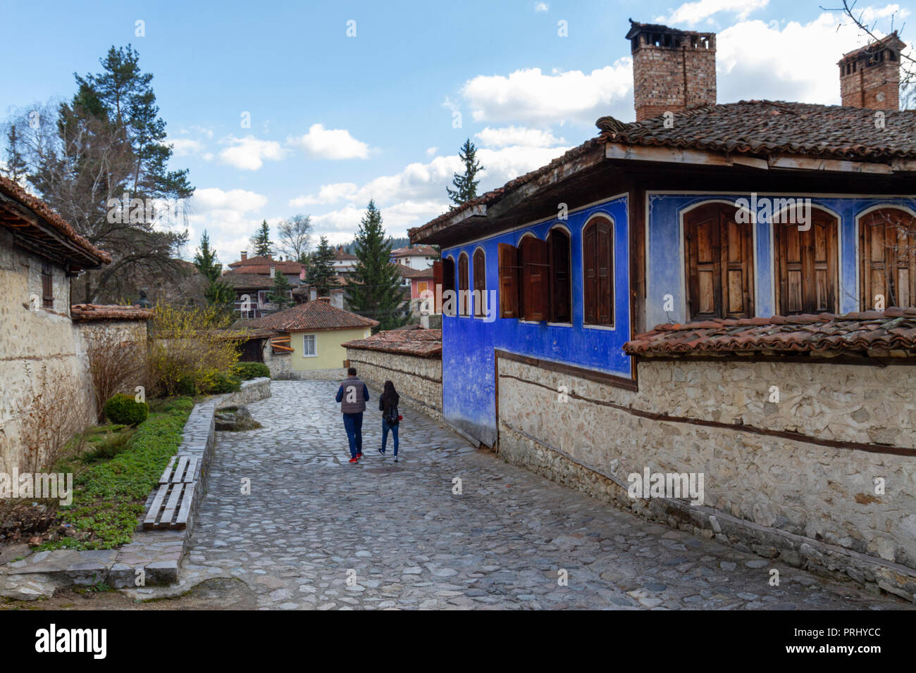 A couple walk along a cobbled street in Koprivshtitsa, Central Bulgaria. Stock Photo