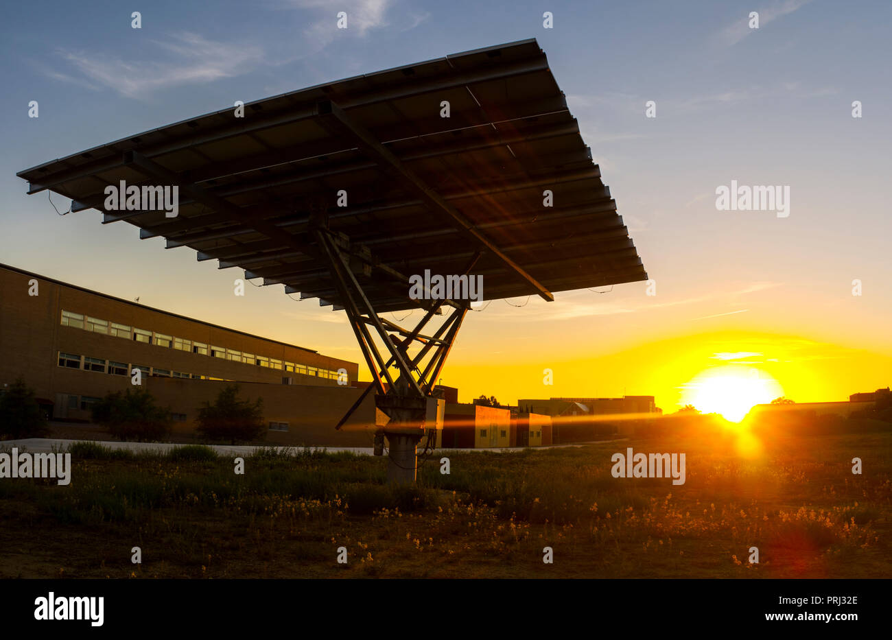 Urban photovoltaic panel with solar tracker placed outdoors building Stock Photo