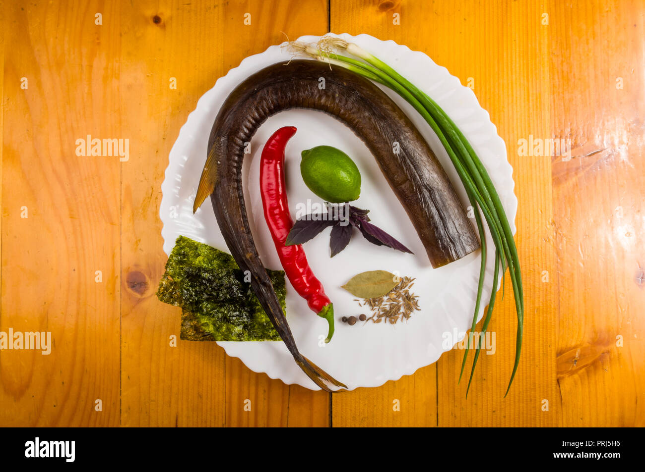 still life - Garfish, billfish raw and fresh, top view, with onions, lemon, prepared for cooking Stock Photo