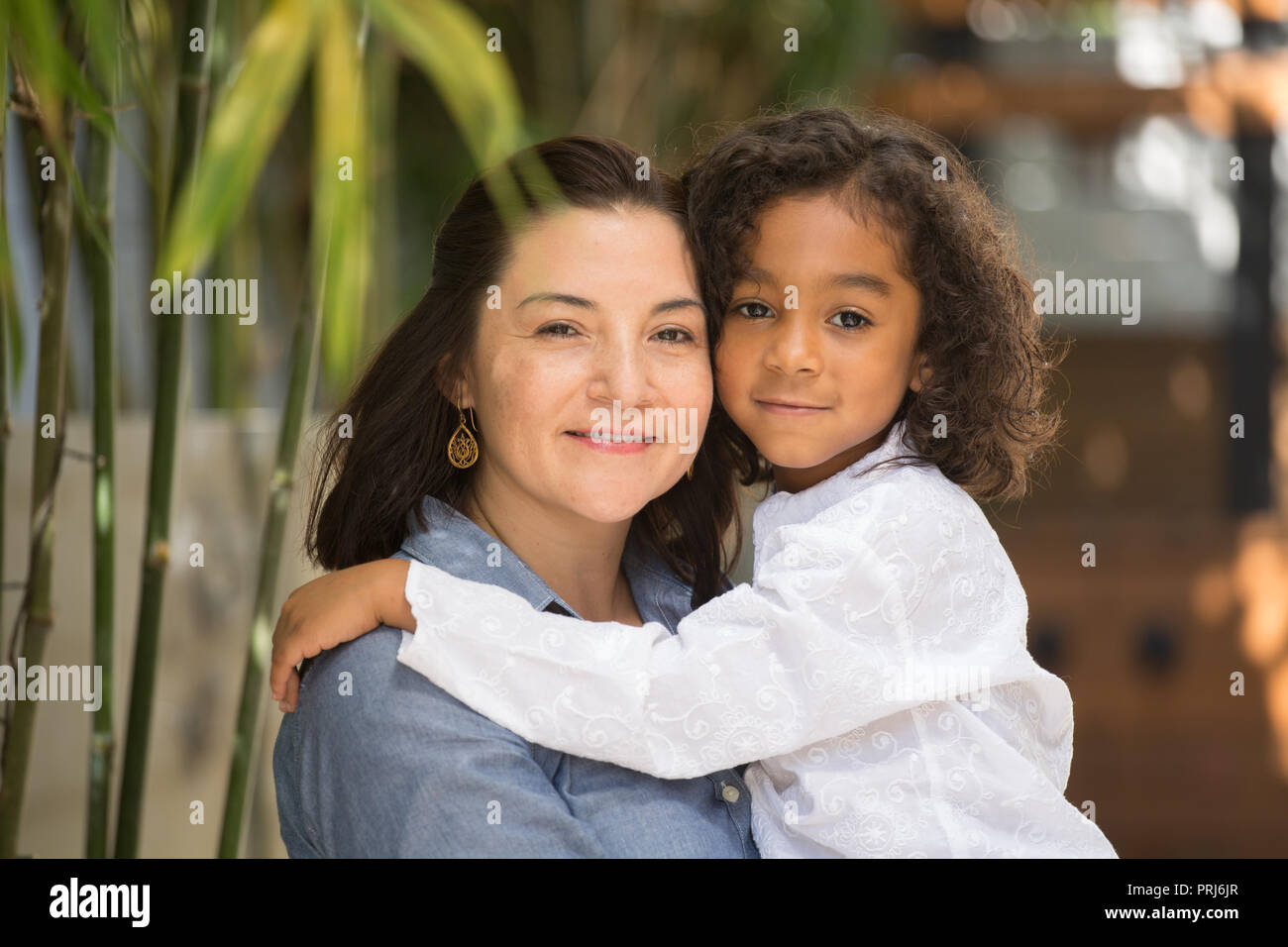 Portrait of a Hispanic mother and her daughter laughing. Stock Photo