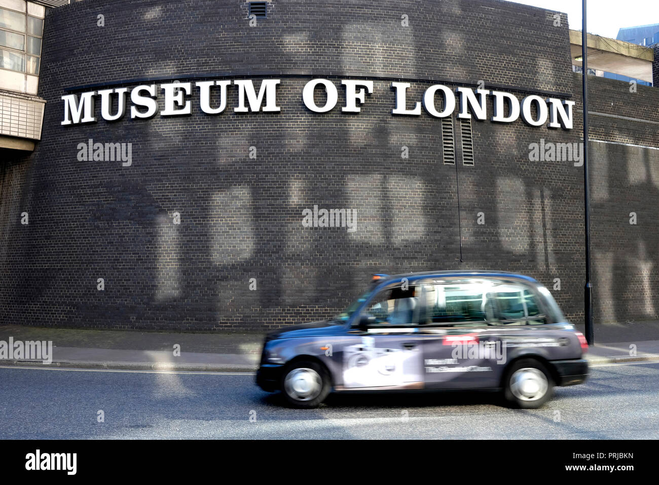 A black cab drives past the museum of London Stock Photo