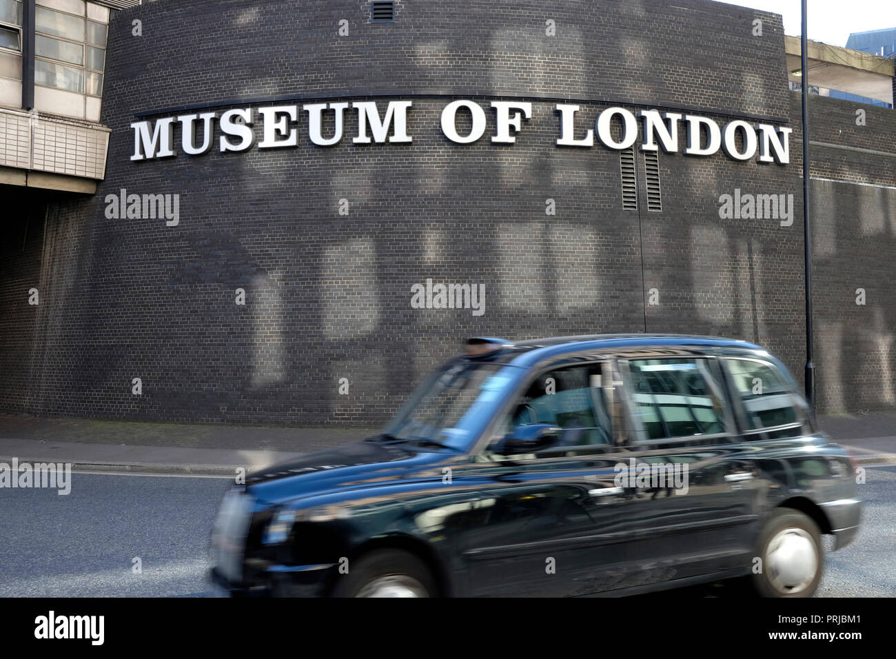 A black cab drives past the museum of London Stock Photo