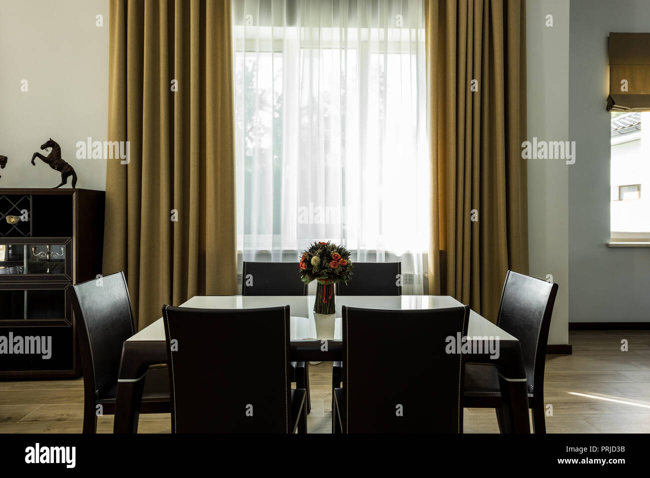 interior view of stylish dining room with table, chairs and big window Stock Photo