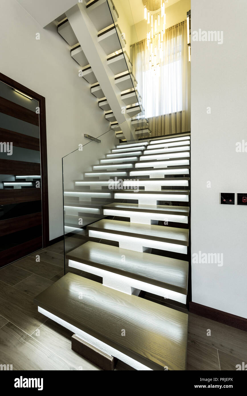 interior view of empty modern stairs with glass railings and door Stock Photo