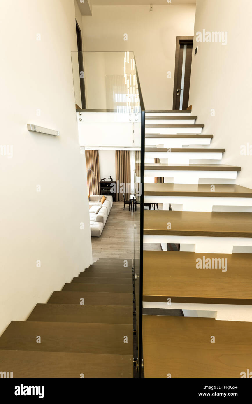 interior view of modern stairs with glass railings to living room Stock Photo