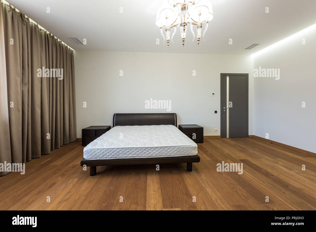 interior of empty bedroom with curtains and mattress on bed Stock Photo
