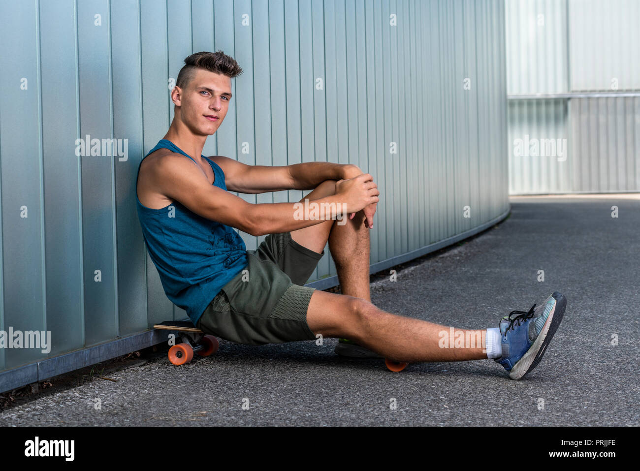 Teenager, 17 years, sits on longboard, Germany Stock Photo