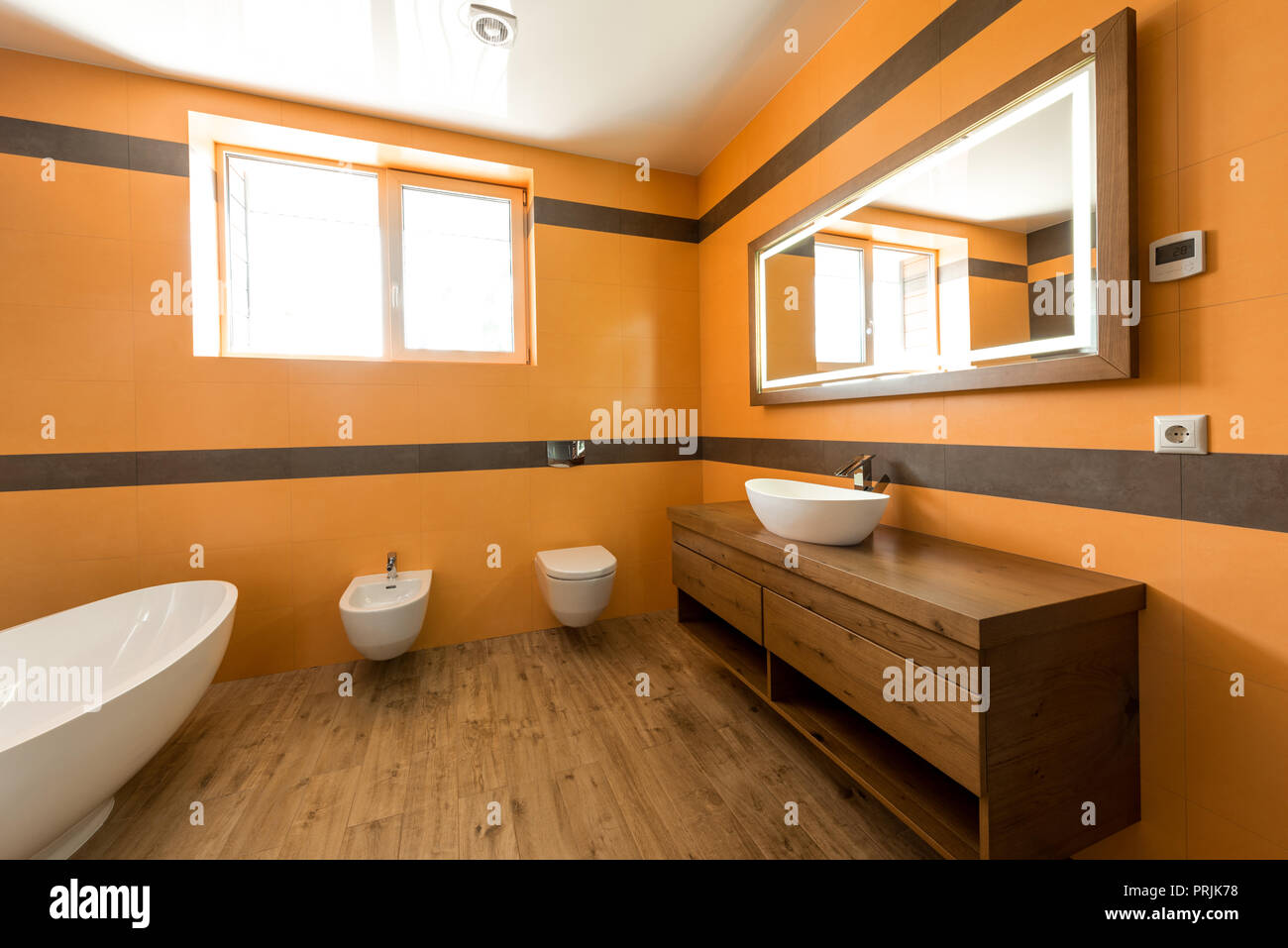 interior of modern bathroom in orange and white colors Stock Photo