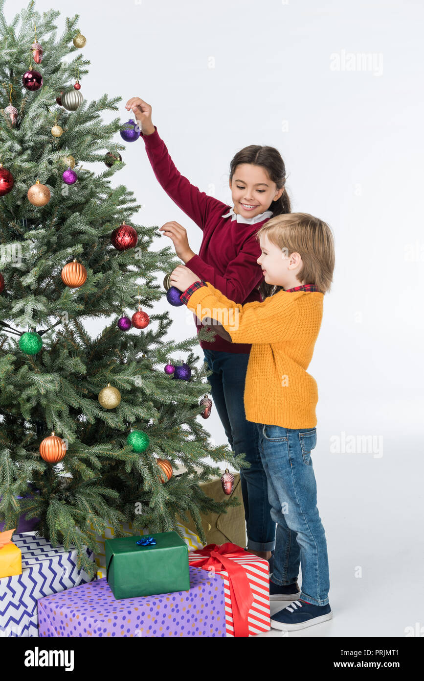 Happy siblings decorating christmas tree with presents isolated on ...