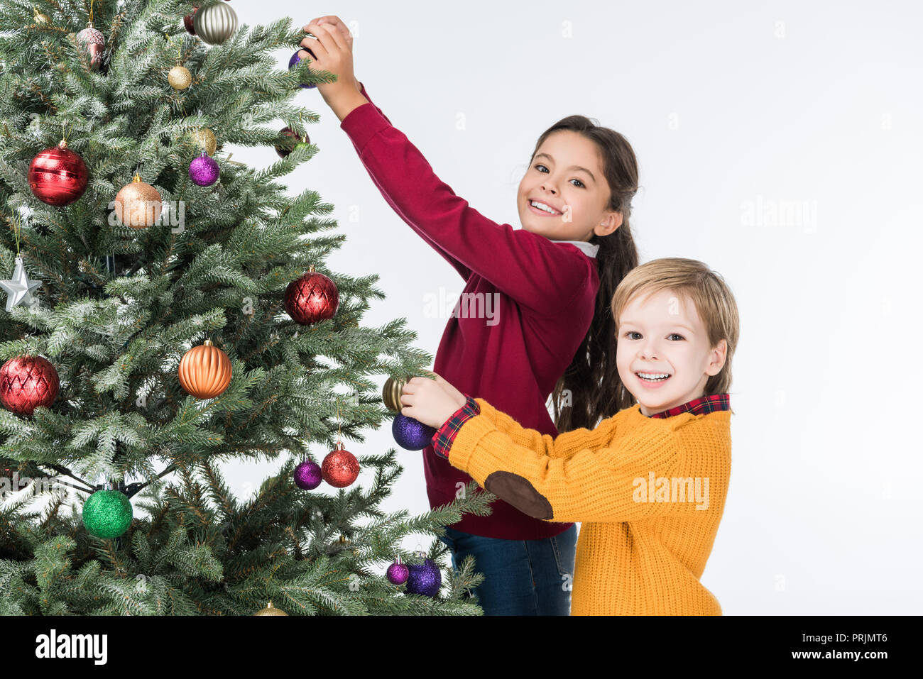 Happy siblings decorating christmas tree with glass balls isolated on ...