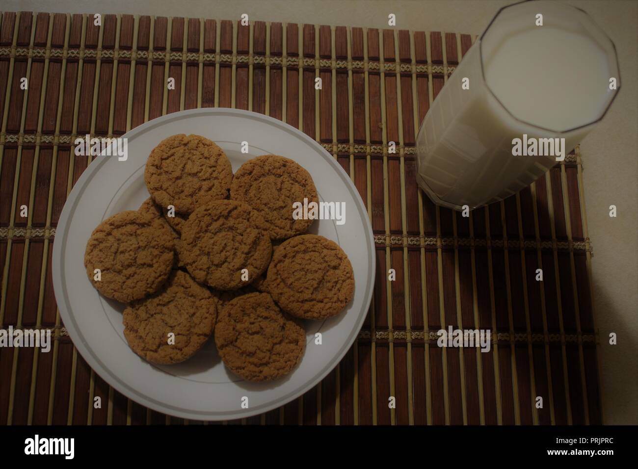 Pumpkin spice cookies and milk on a wooden placemat Stock Photo