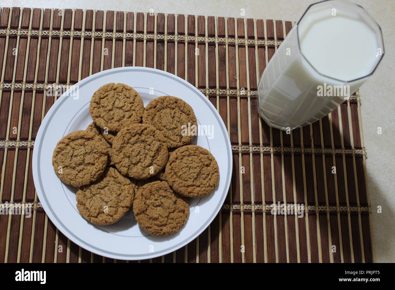 Pumpkin spice cookies and milk on a wooden placemat Stock Photo