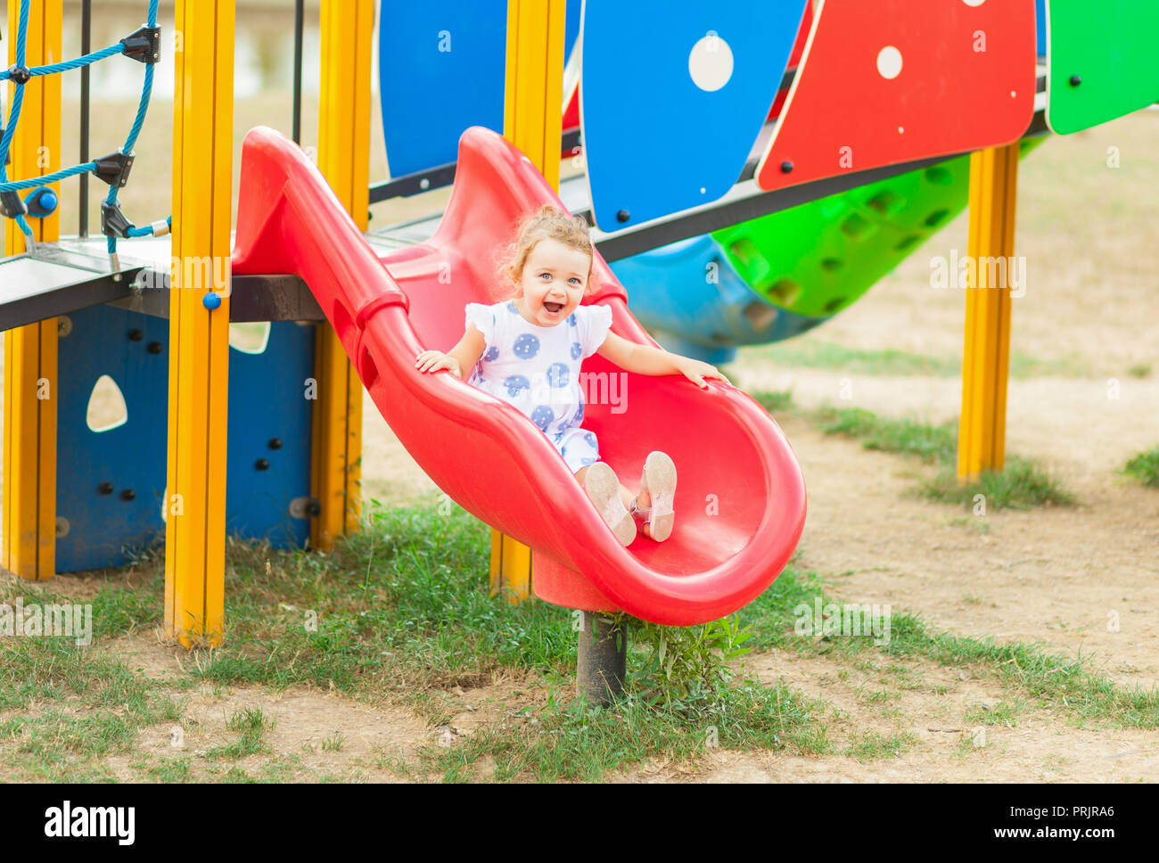 Young girl sliding down slide at playground - Fort Lauderdale