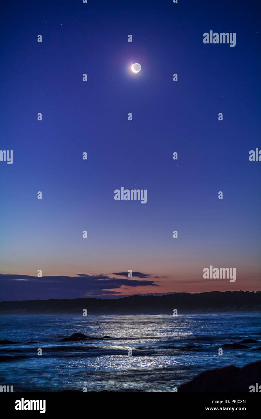 The “upside-down” waxing crescent Moon in the evening sky from Victoria, Australia, at Cape Conran, West Cape area, on the Gippsland Coast, at latitud Stock Photo