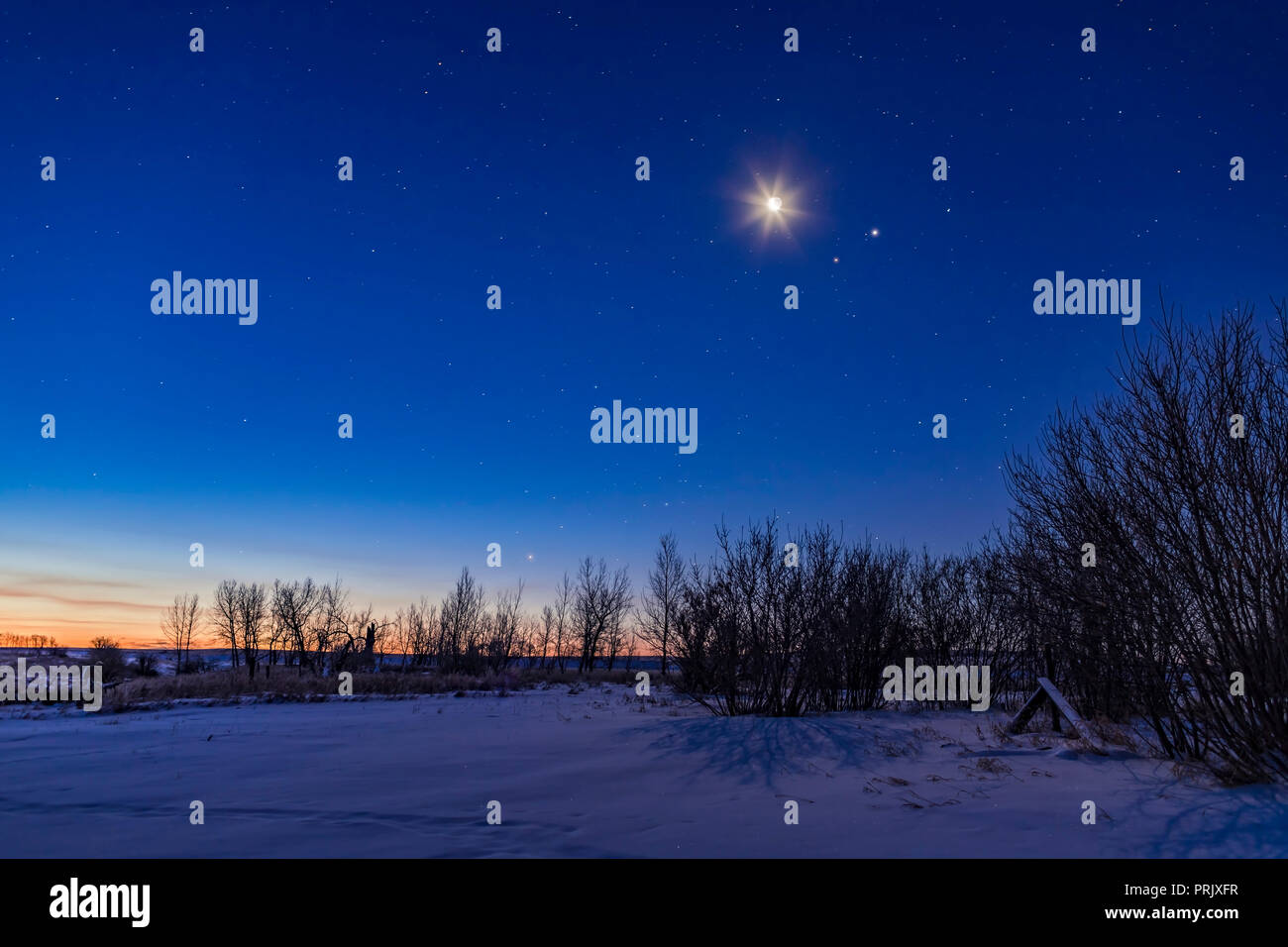 The morning sky of January 11, 2018, with the waning crescent Moon shining above the pairing of Mars (left) and Jupiter (right). The Moon and planets  Stock Photo