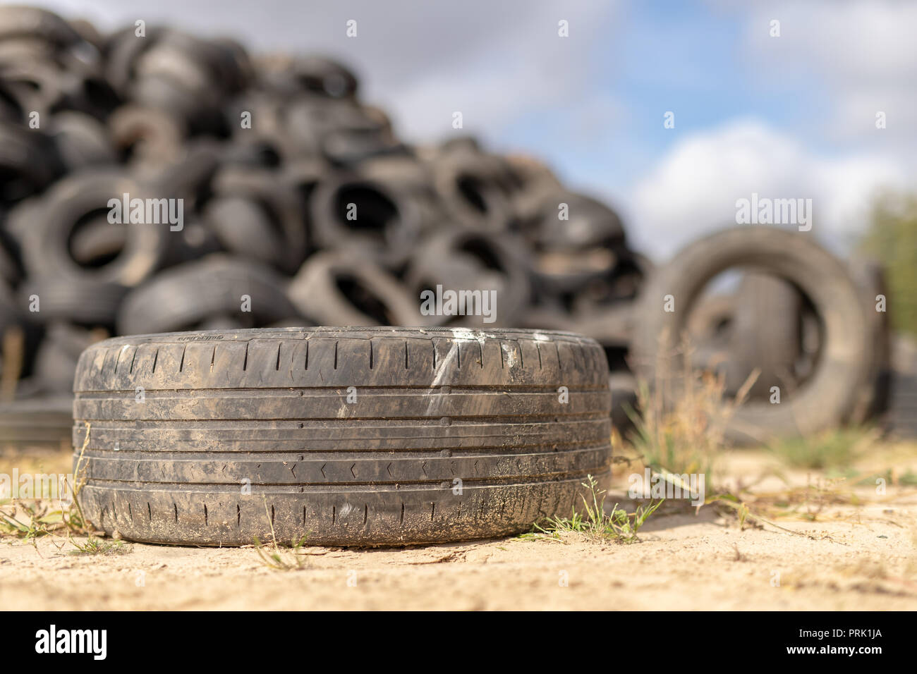 A stack of tires on an old garbage dump. Old worn out tires piled up