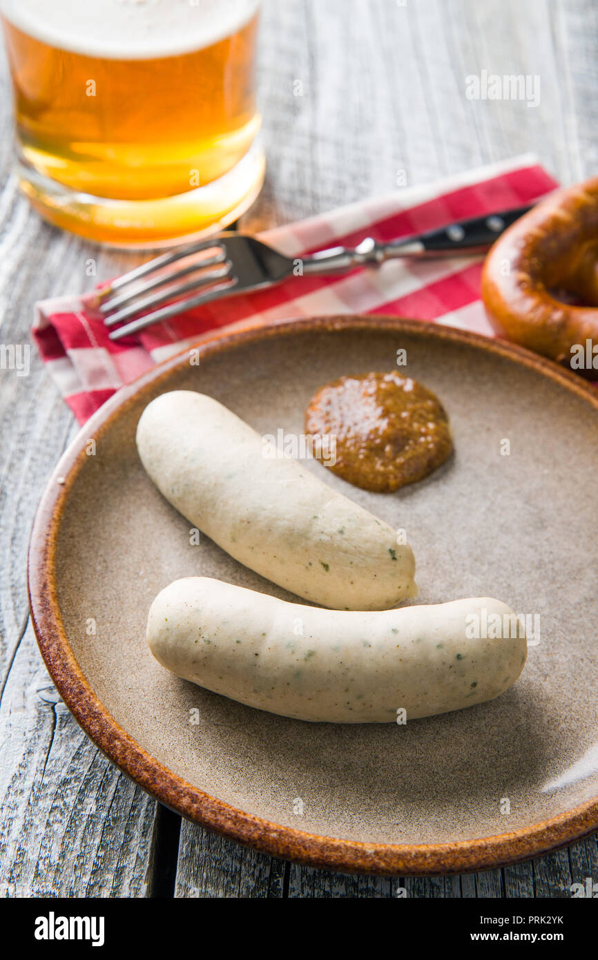 The bavarian weisswurst, pretzel and mustard on wooden table. Stock Photo