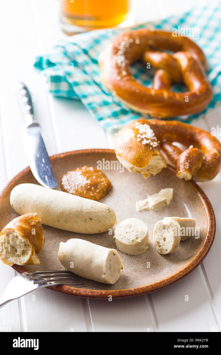 The bavarian weisswurst, pretzel and mustard on white table. Stock Photo