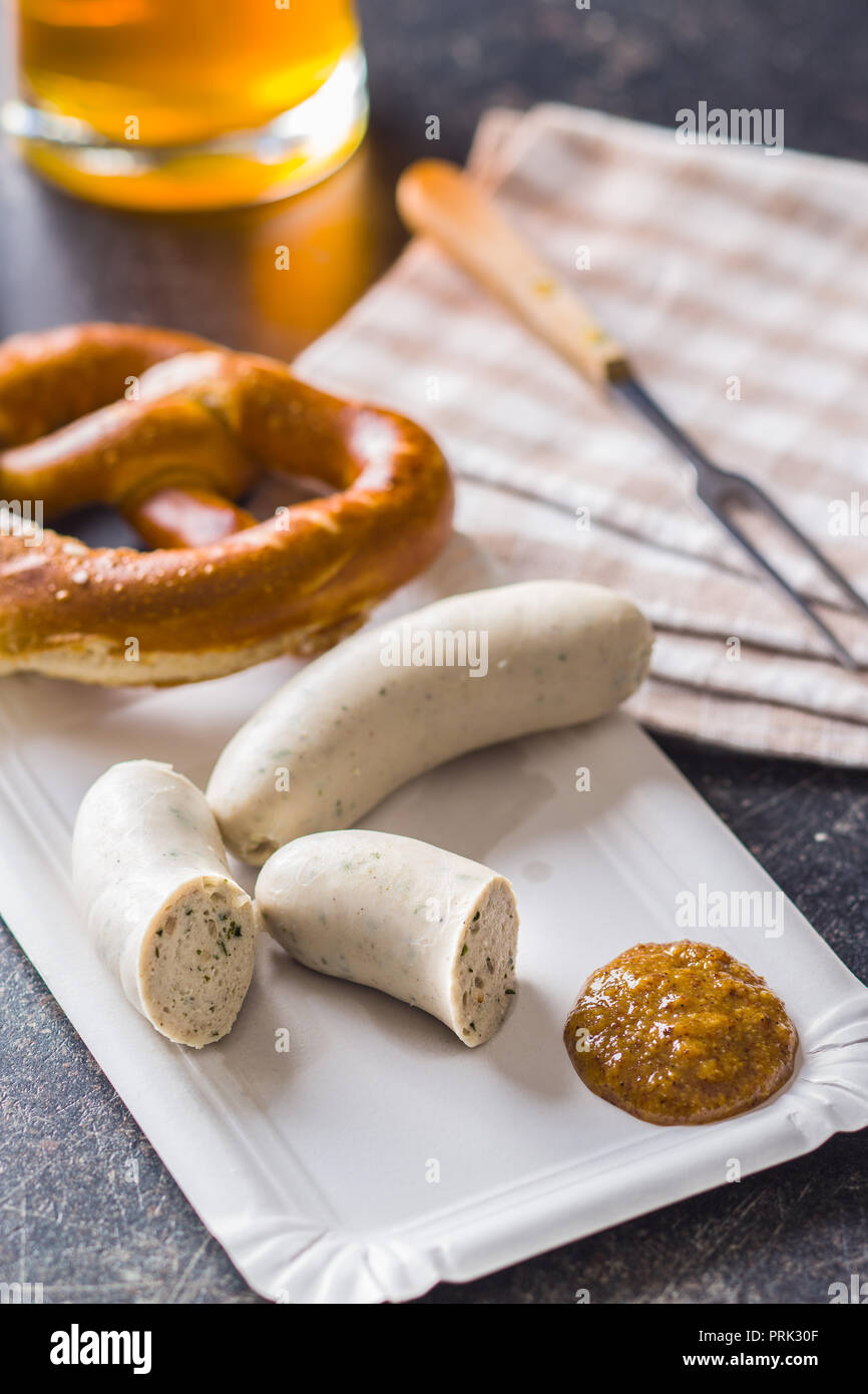 The bavarian weisswurst, pretzel and mustard on paper plate. Stock Photo