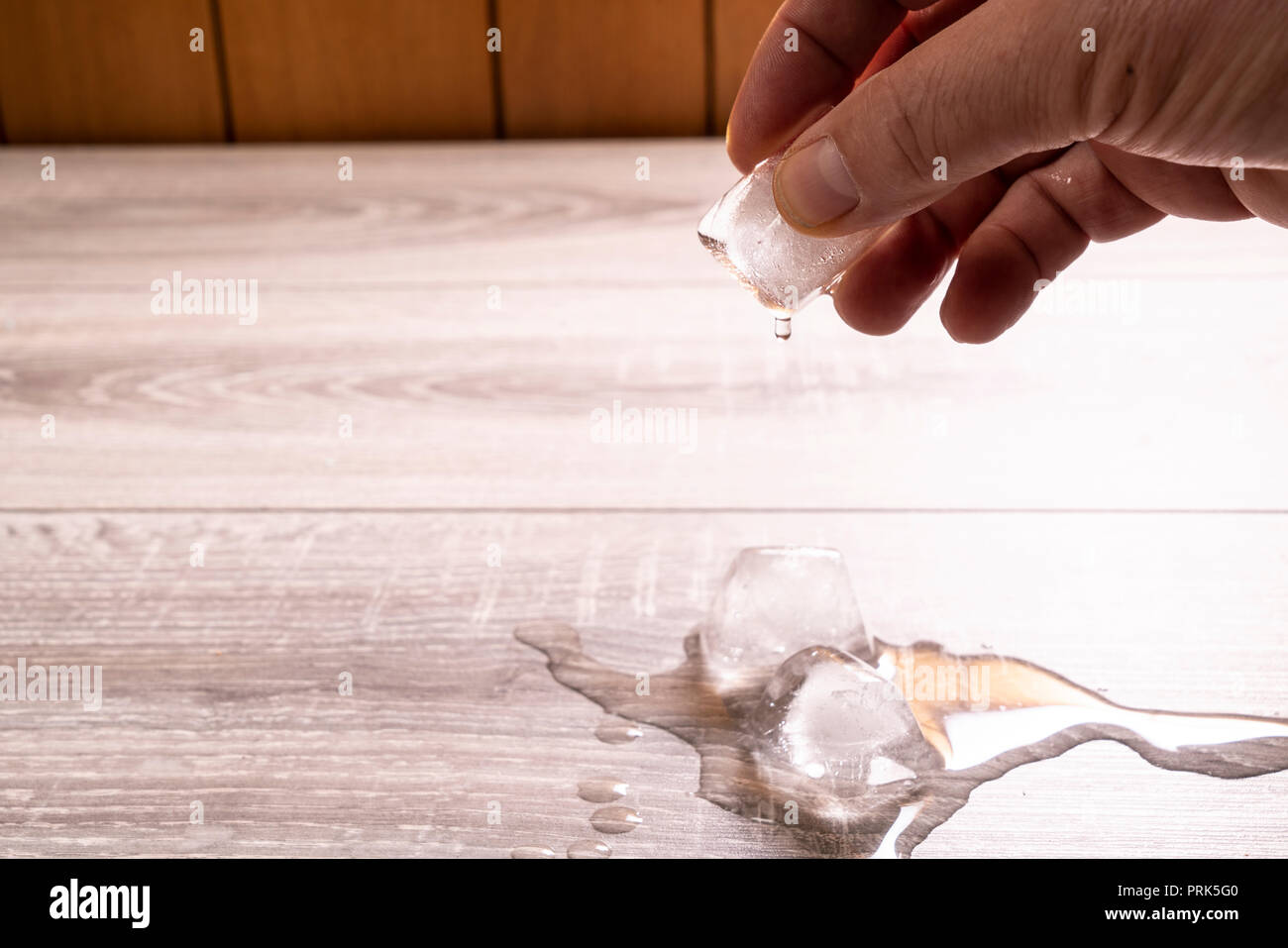 a cube of ice as it melts in your hand Stock Photo