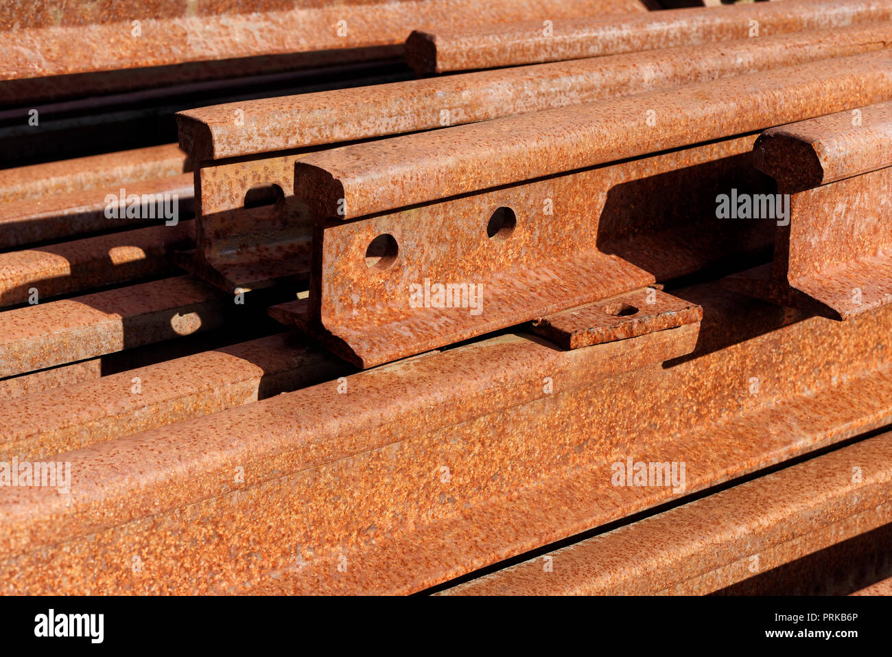 Backgrounds and textures: group of rusty steel rails, stacked in a pile outdoors, industrial abstract Stock Photo
