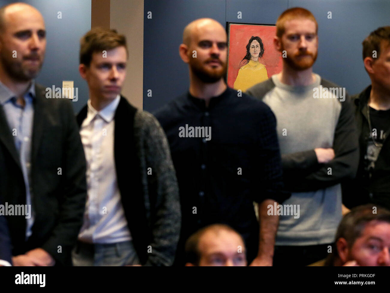 'A.L.' by Will O'Kane hangs in the gallery as artists pose for a group photograph at a press preview in Dublin as the National Gallery of Ireland announced the shortlist for the Zurich Portrait Prize. The winner will be announced on Monday, 22nd October 2018. Stock Photo