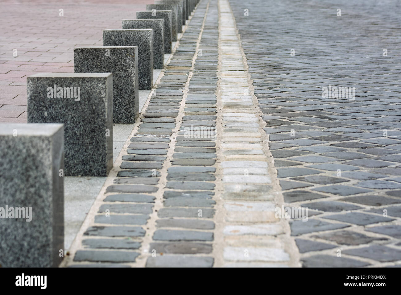 Columns of gray marble on the pavement lined with gray stone and red tiles. Stock Photo
