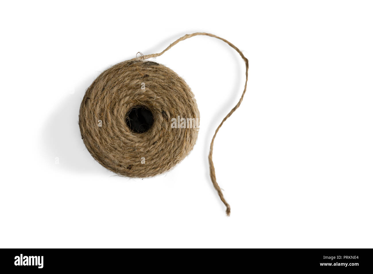 Top down view on a ball of jute twine or string with natural twisted fibers wound into a ball for household and domestic use on a white background Stock Photo