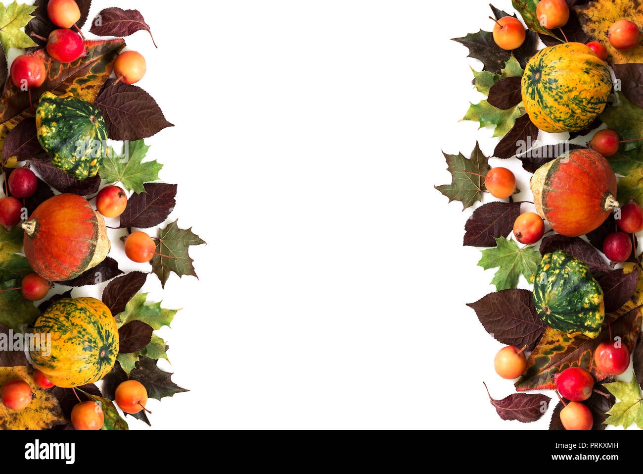 Pumpkins with fall leaves and paradise apples over white background. Top view. Stock Photo