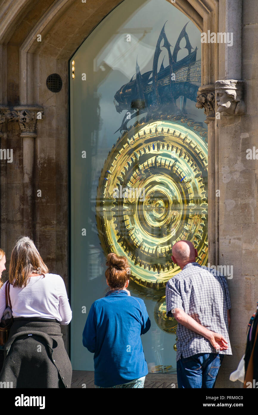 People looking at the Corpus gold handless clock, Cambridge, UK Stock Photo