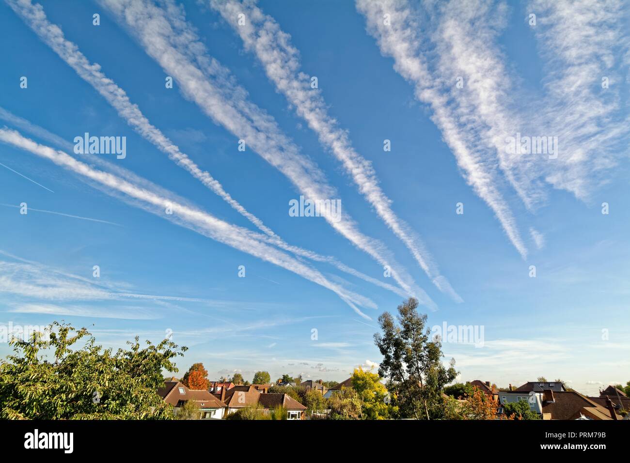 Receding aircraft contrails  against a blue sky Surrey England UK Stock Photo