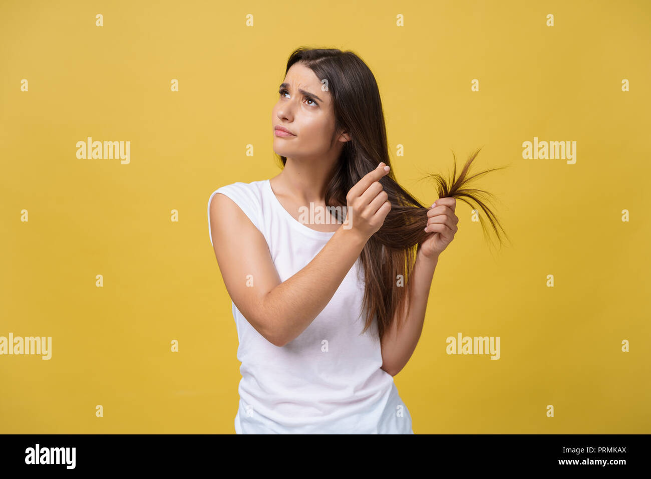 Woman hand holding her long hair with looking at damaged splitting ends